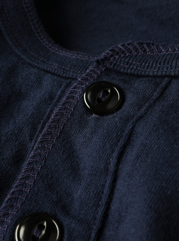 .02 ネック部分のボタンがアクセントになるヘンリーネック